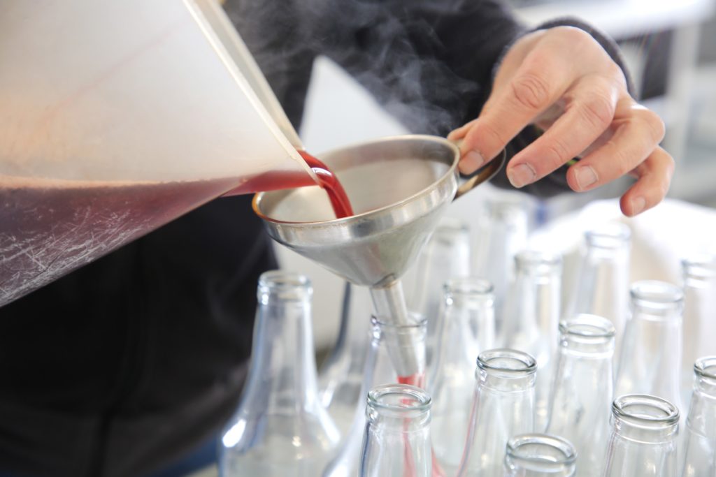 on voit les mains de Florence verser le sirop encore chaud dans la bouteille!
